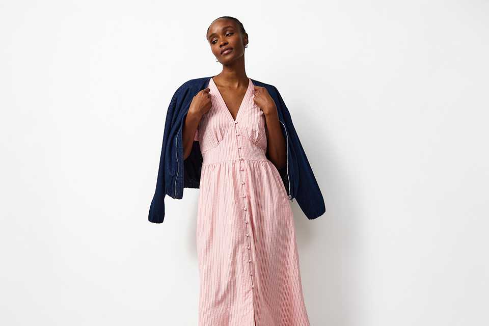 Lightweight pink midi dress layered with a jacket, styled as a festival outfit for changeable weather.