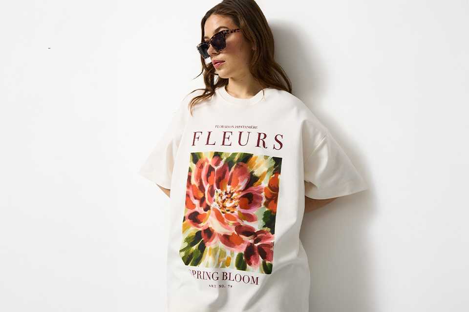 Oversized white graphic festival T-shirt styled as a relaxed festival outfit, ideal for casual summer dressing.