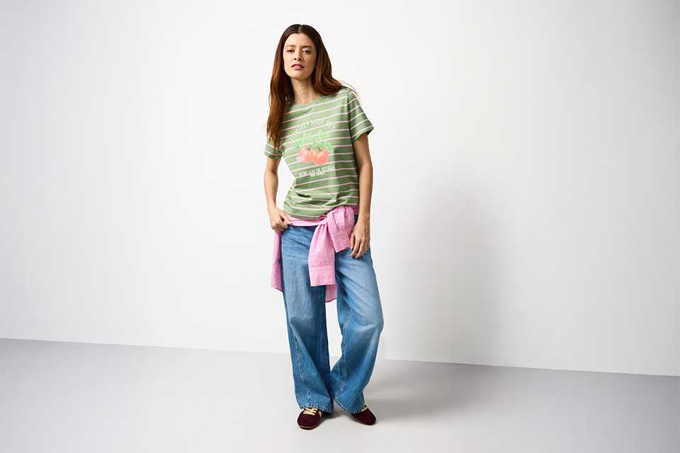 Striped festival T-shirt styled with wide-leg jeans, showcasing a versatile festival capsule outfit.