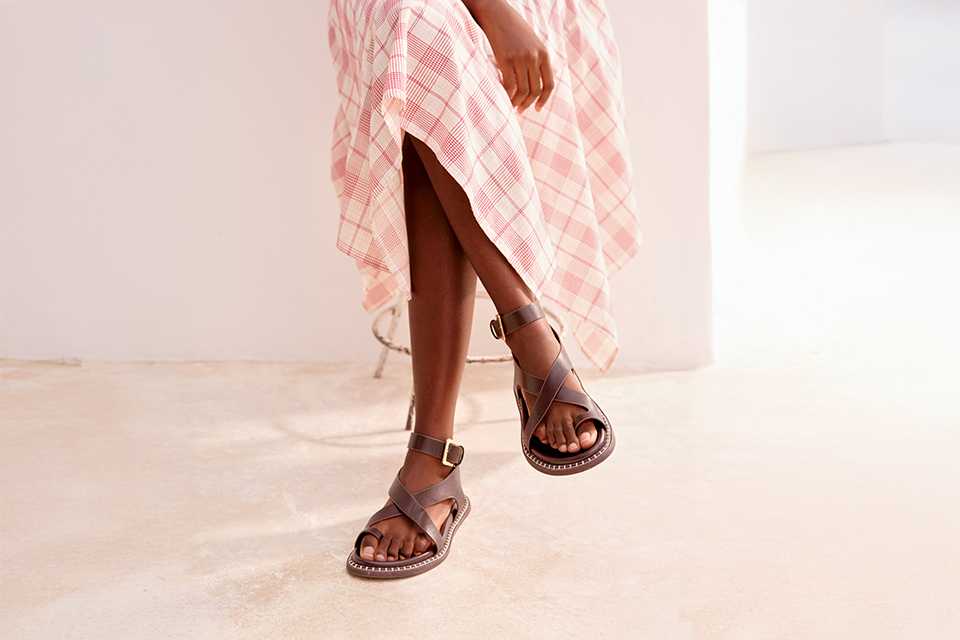 Flat leather summer sandals paired with a lightweight printed dress for comfortable everyday warm‑weather wear.