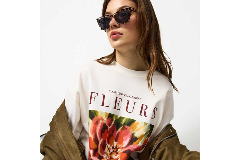 Graphic slogan T-shirt styled with casual jacket for relaxed city break outfit.
