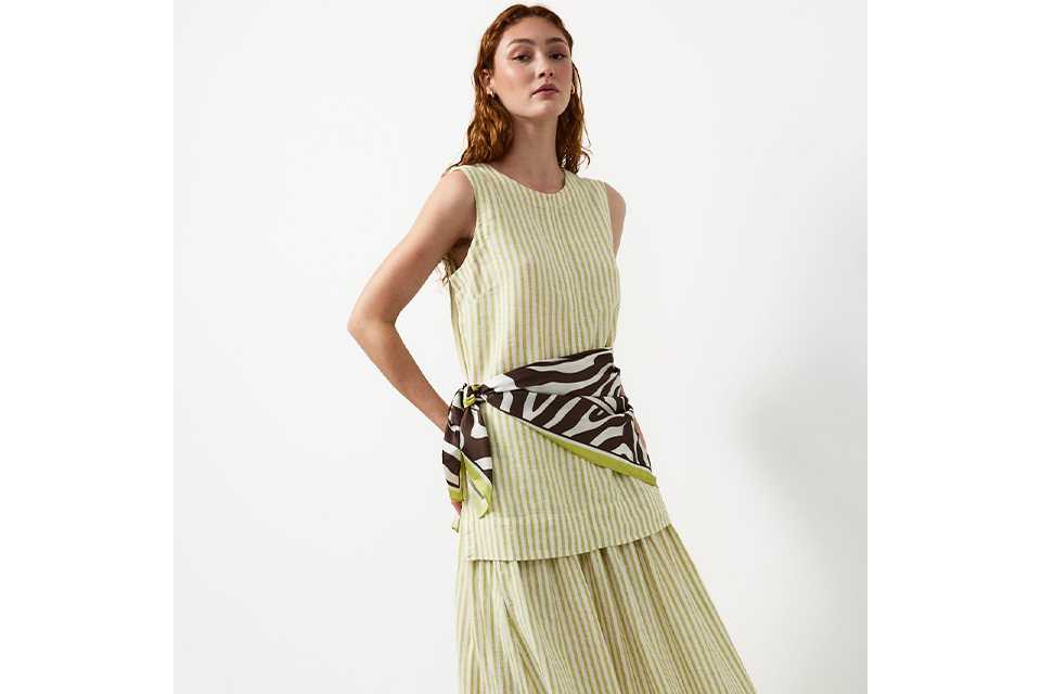 Woman wearing a pale green and cream stripe maki skirt and top.