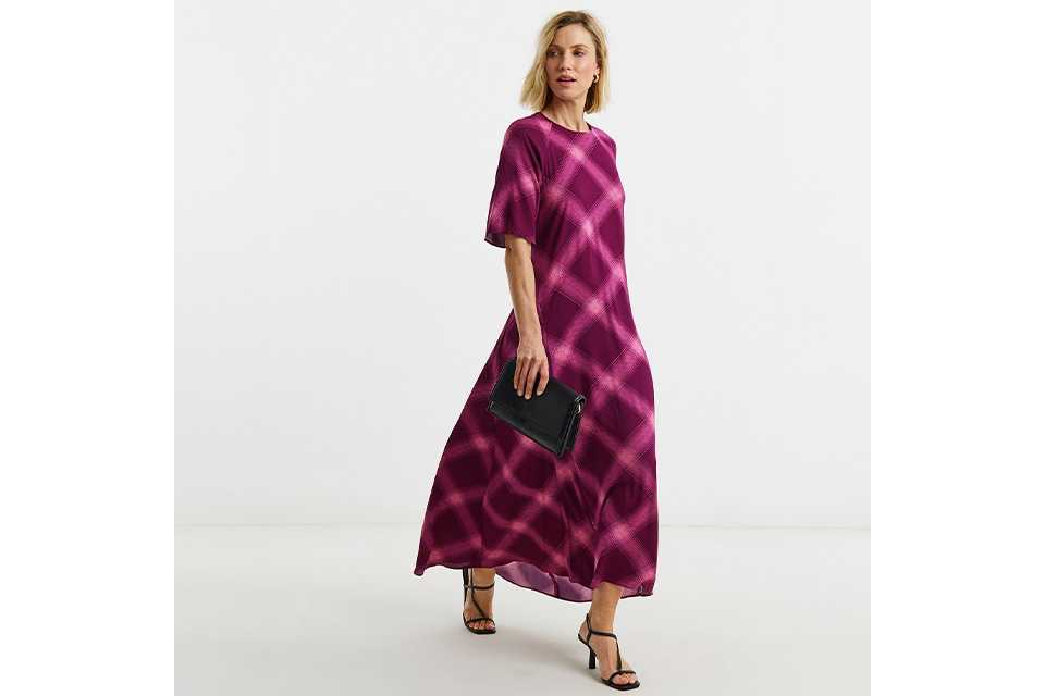 Woman wearing a pink and purple maxi dress with heels.