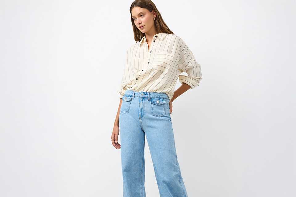 Cream striped button-through shirt with rolled sleeves, styled with light wash wide-leg jeans for a relaxed smart-casual look.