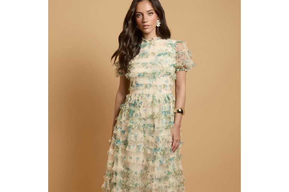 Cream floral ruffle maxi dress with tiered textured layers, short puff sleeves, high neckline and flowing silhouette.