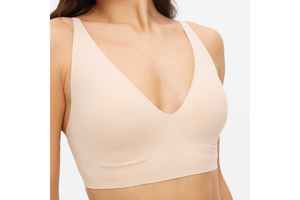 A woman wearing a nude non wired bralette.