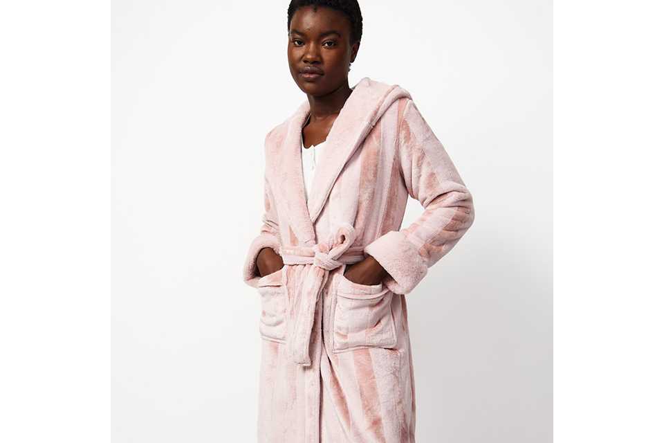 A woman wearing a pale pink dressing gown.