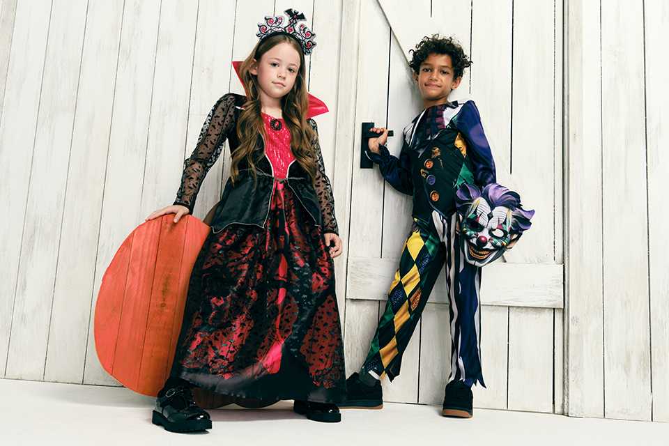 Two children dressed up in Halloween costumes.