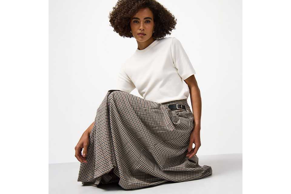 Model wearing a white T-shirt and checked maxi skirt from the Tu Clothing trends and collections range.