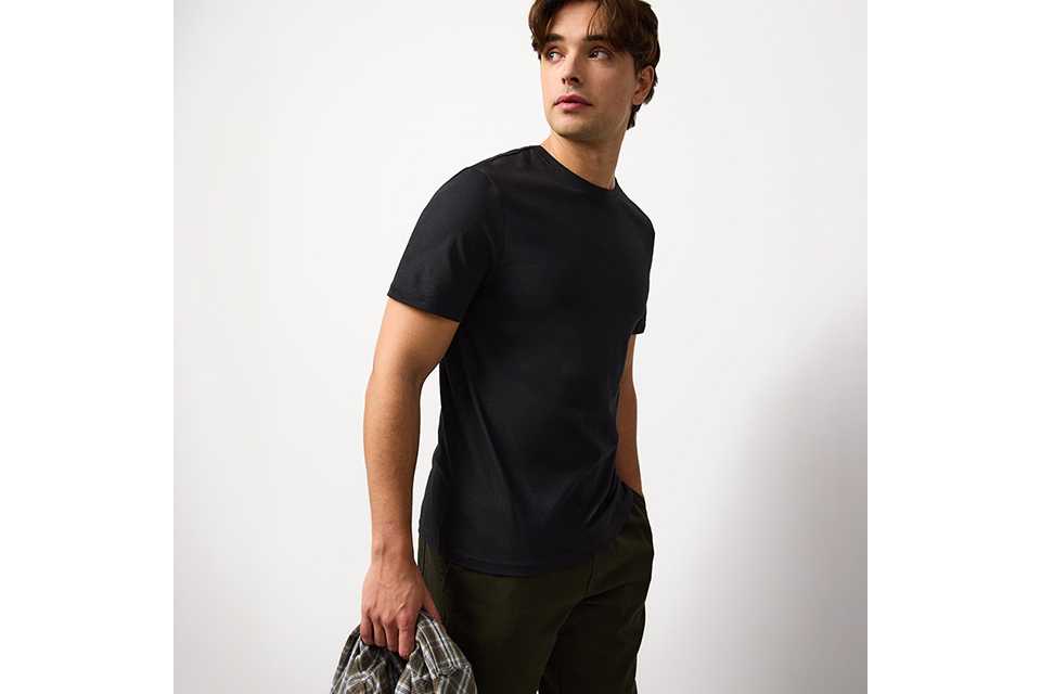 Men's black crew neck t-shirt styled with casual trousers for everyday autumn outfits.