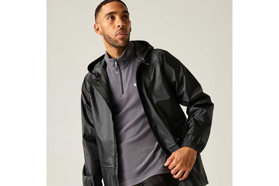 Men's lightweight black jacket layered over knitwear for versatile autumn layering outfits.