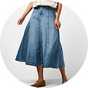 Light wash denim midi skirt with a flared silhouette, panel detailing, and a high-waisted fit, styled with a cream sleeveless top and ballet flats.
