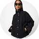 Black denim jacket with a high stand collar, button-front fastening, and side pockets, styled with sunglasses for a modern casual look.