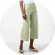 White sleeveless top paired with sage green cropped wide-leg trousers and sandals.