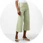 White sleeveless top paired with sage green cropped wide-leg trousers and sandals.
