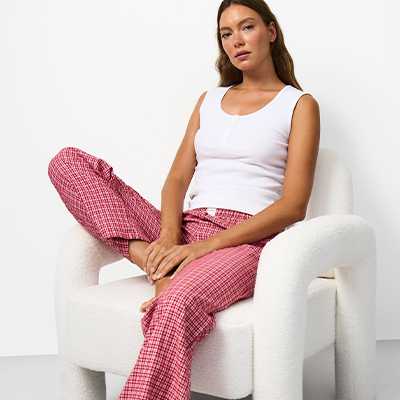 Women's pyjama separates featuring a white vest top and pink checked lounge trousers, mix-and-match nightwear.