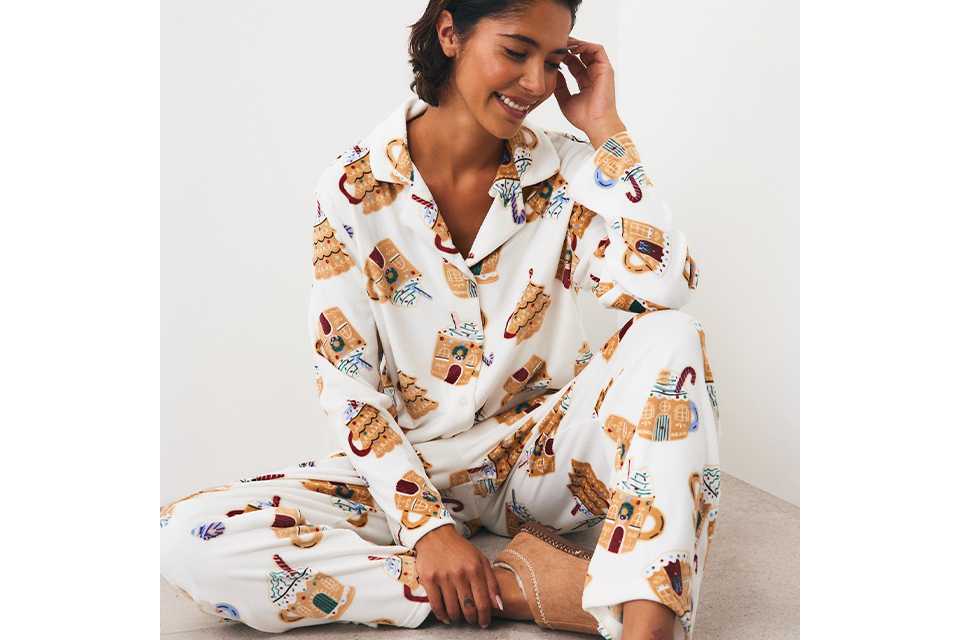 Person wearing food-themed Christmas pyjamas featuring festive treats and novelty seasonal prints.