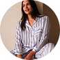 Person relaxing in striped Christmas pyjamas for a cosy festive movie night at home.