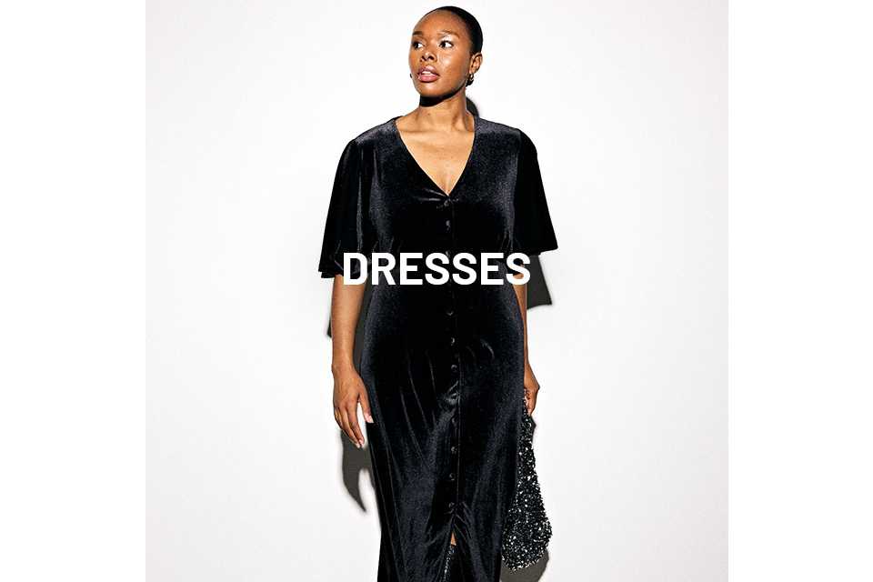 Woman wearing black velvet dress and carrying a black sequin handbag.