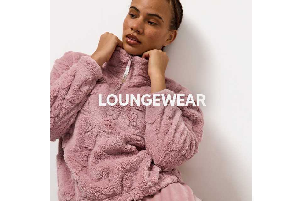 Woman wearing pink carved bow fluffy top and slinky bottoms.