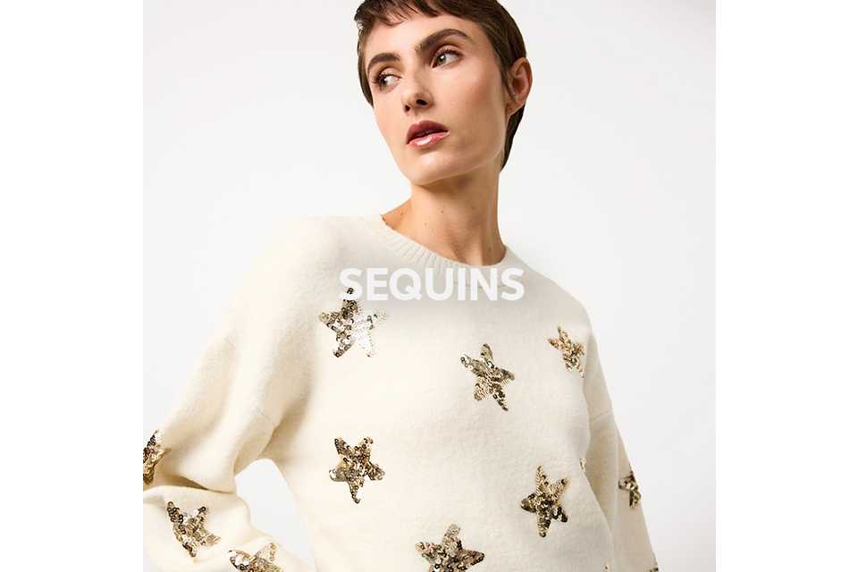 Woman wearing cream star sequin embellished jumpers.