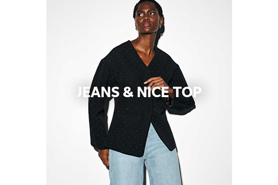 Woman wearing black structured blazer with light blue jeans.