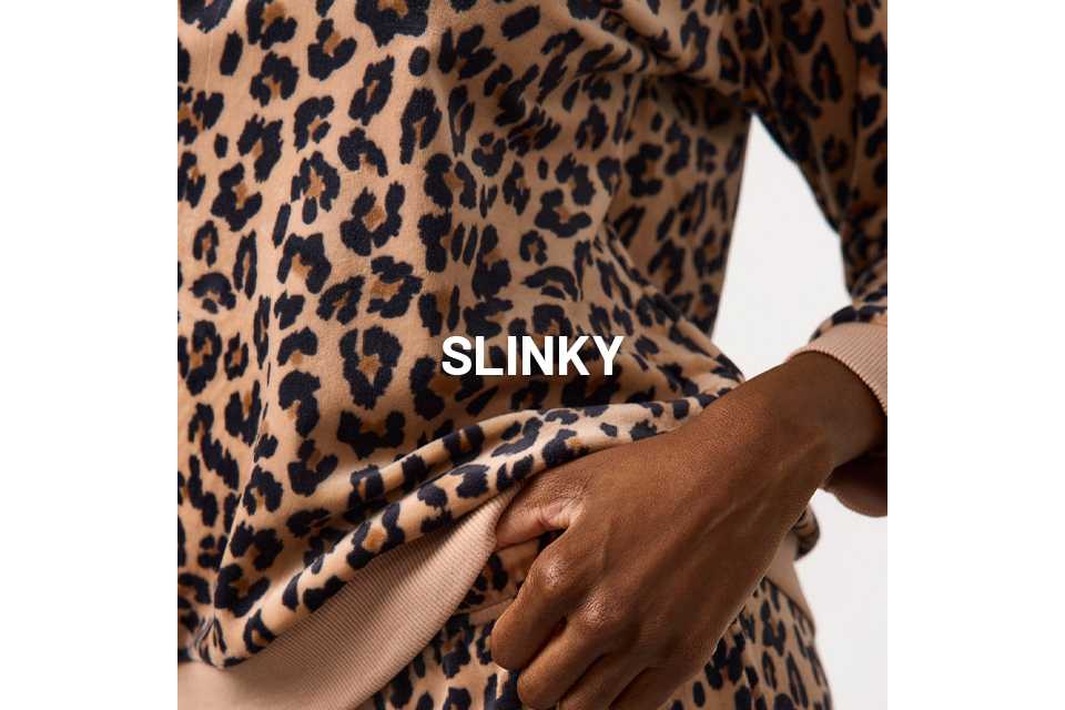 Close-up of beige loungewear set with bold black and brown leopard print, featuring ribbed cuffs and relaxed fit.