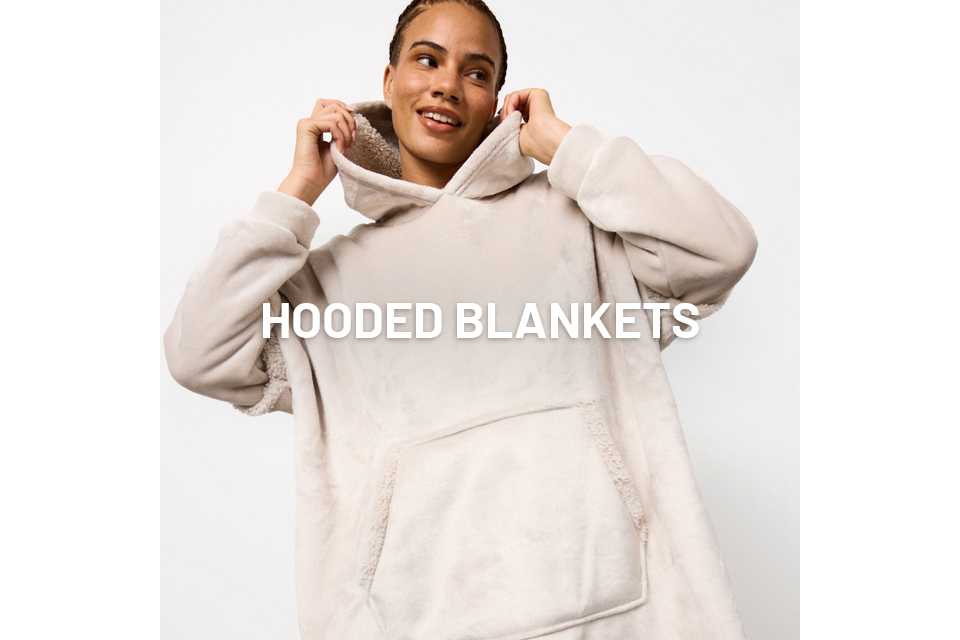 A woman wearing a neutral hooded blanket.