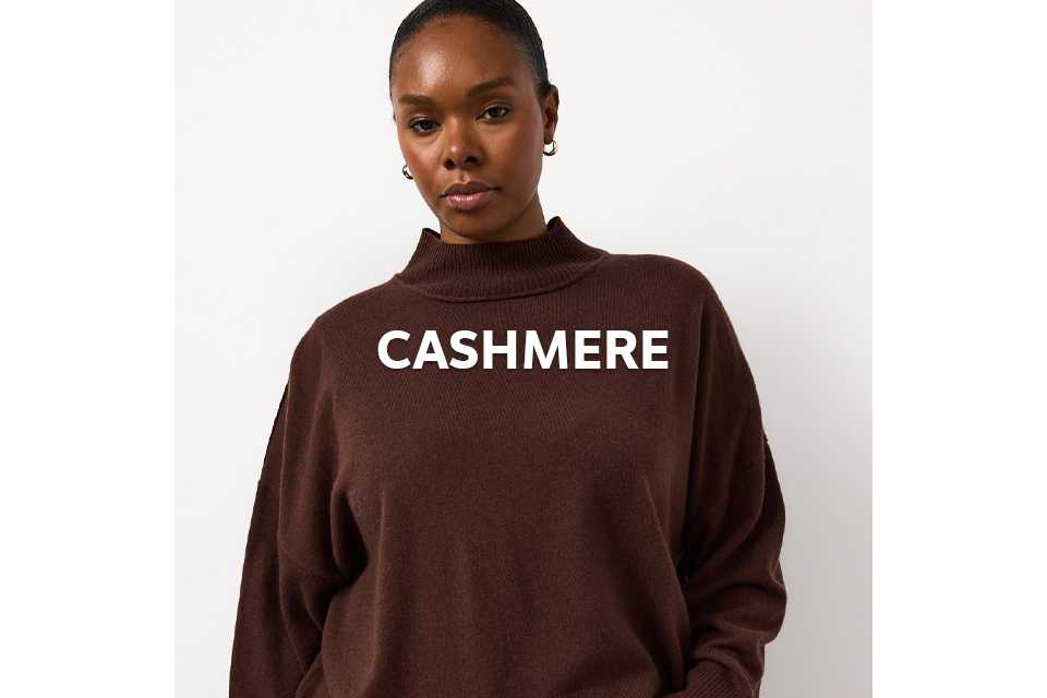 Woman wearing a brown cashmere merino high neckline jumper.