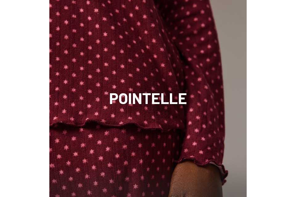 Close-up of burgundy ribbed loungewear set with pink star print, featuring lettuce-edge hem and cuff detail.
