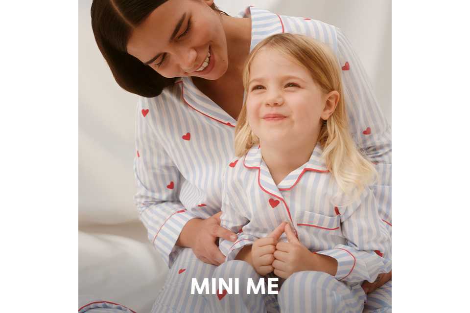 Matching striped pyjama sets with red piping detail worn by an adult and child.