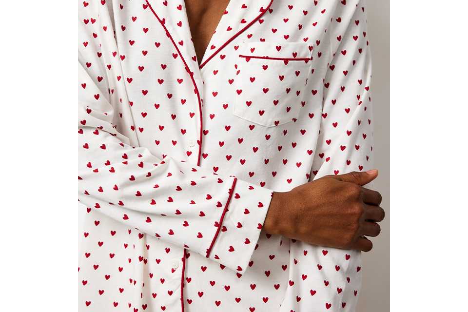 White button-up pyjama set with small red heart print.