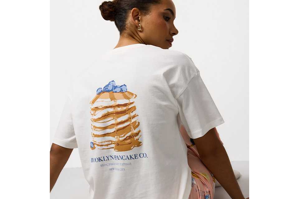 White top with pancake stack illustration and slogan on the back.