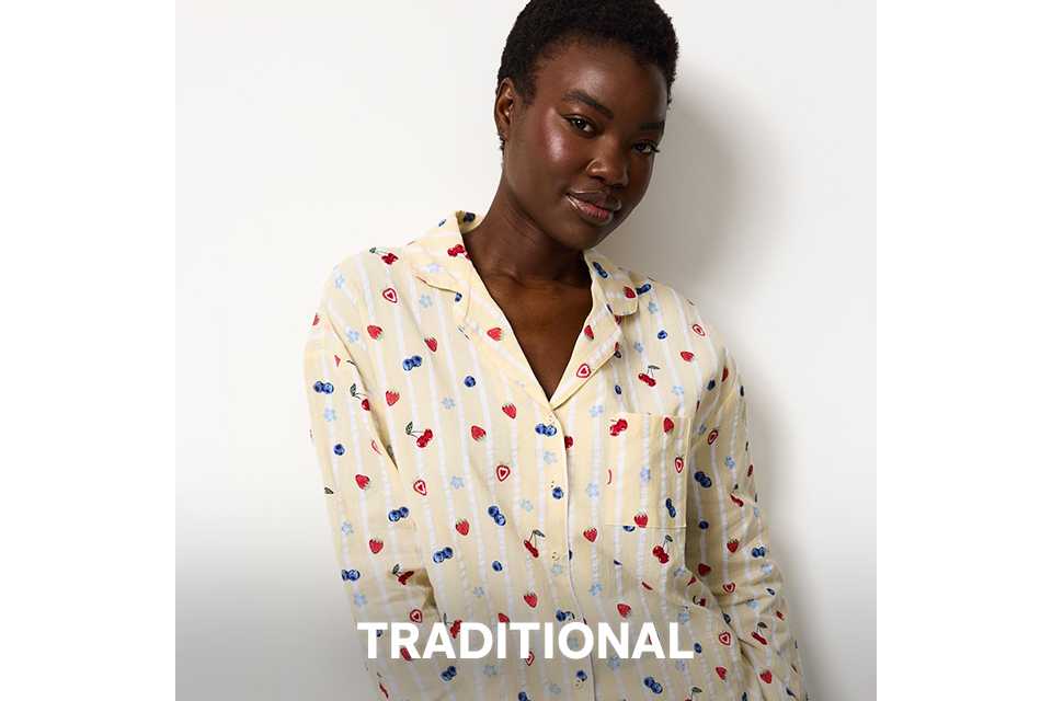 Light-colored button-up pyjama set with small red and blue heart print, styled as traditional nightwear.