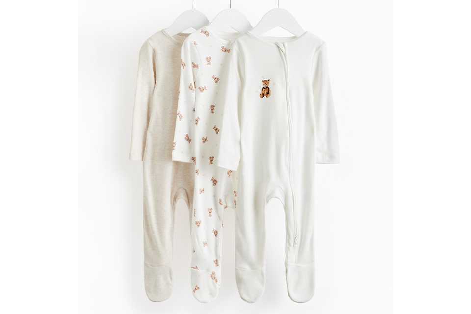 Unisex baby clothing featuring neutral-toned pajamas and playful essentials for newborns.