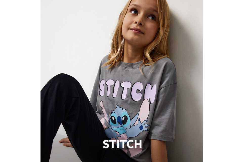 Child wearing a grey T‑shirt featuring a large Stitch graphic from Disney’s Lilo & Stitch.