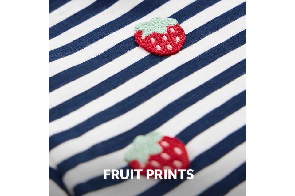 Close-up of a navy and white striped fabric with small embroidered strawberry motifs.