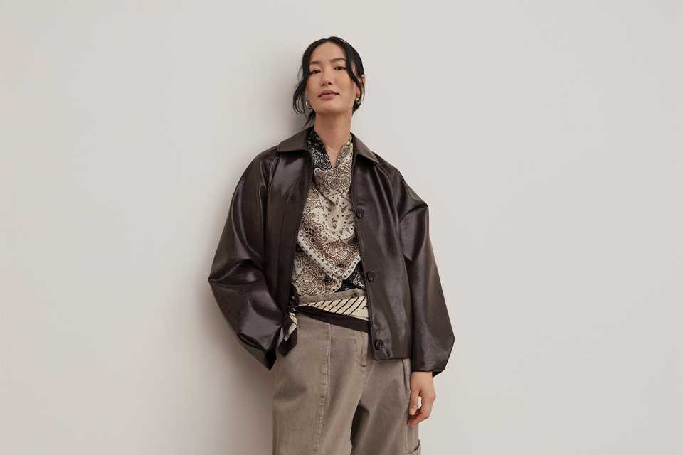 Casual autumn outfits featuring a blue embroidered knit jumper with wide-leg jeans and a beige trench coat layered over red trousers.