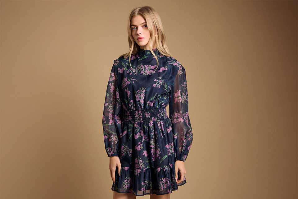Dark floral long-sleeve dress styled for an evening wedding reception with a refined, occasion-ready finish.
