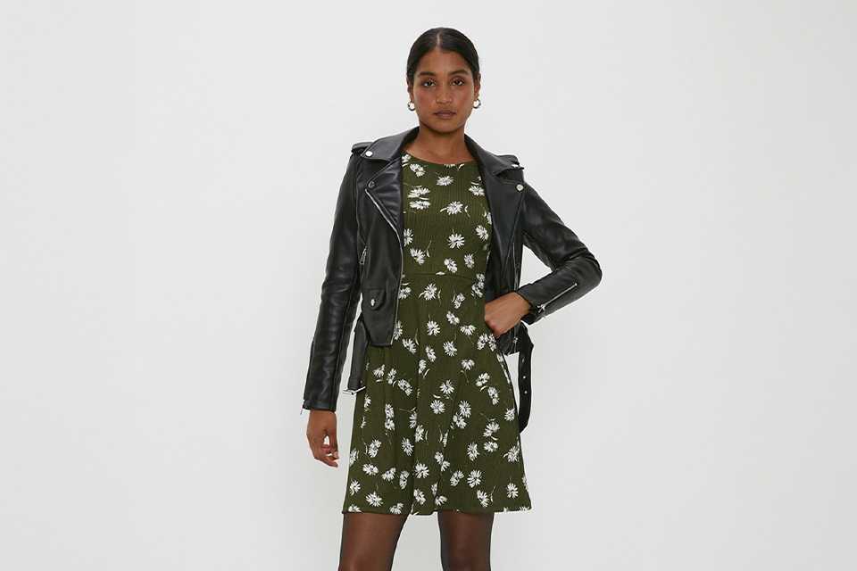Floral wedding guest dress layered with a black leather jacket for a stylish all-weather wedding outfit.