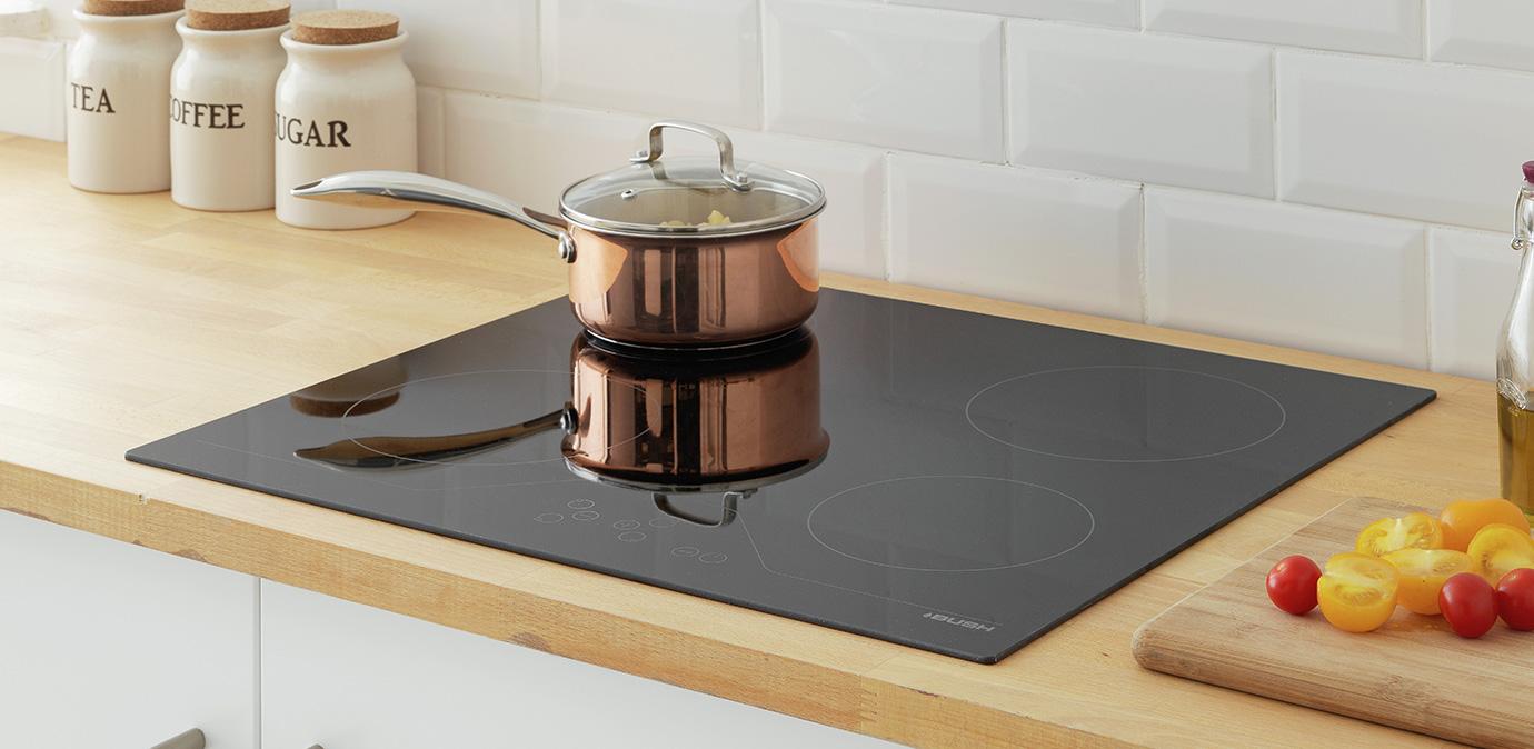 Lifestyle image showing pan in top left corner of a hob on a countertop.