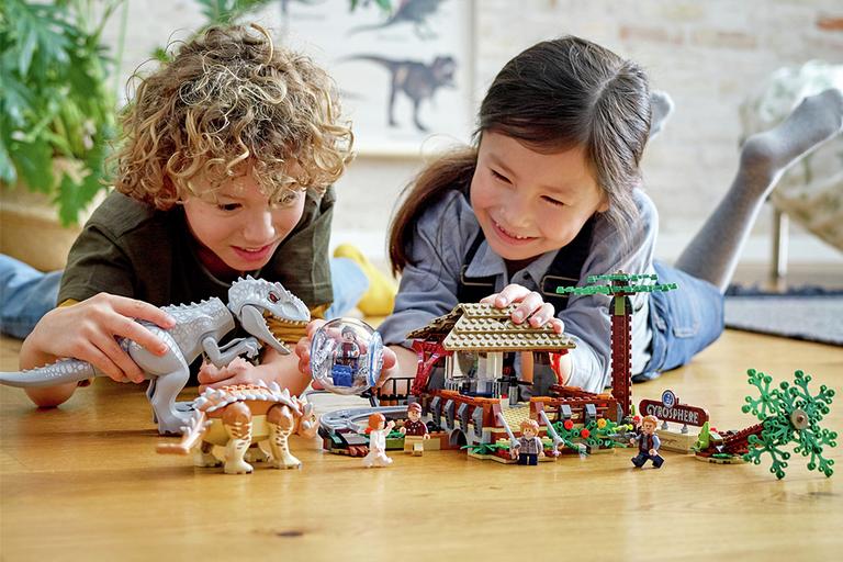 A girl and boy playing with a LEGO® dinosaurs set.