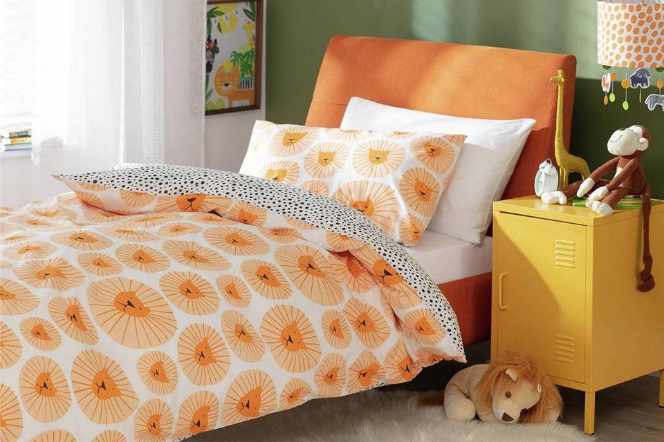 Orange kids bed with lion print bedding.