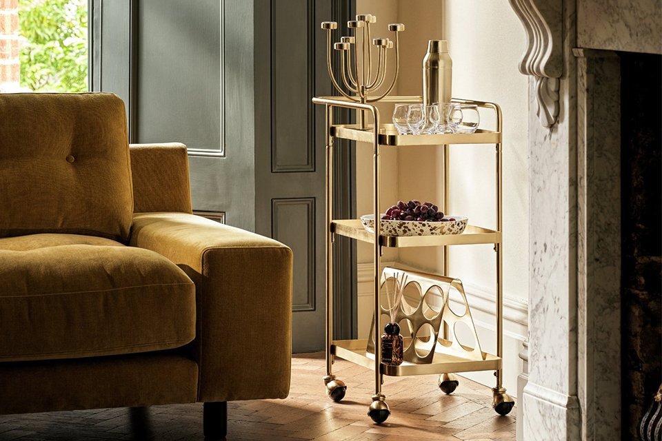 Habitat 60 Gold Edit Drinks Trolley placed next to a mantel.