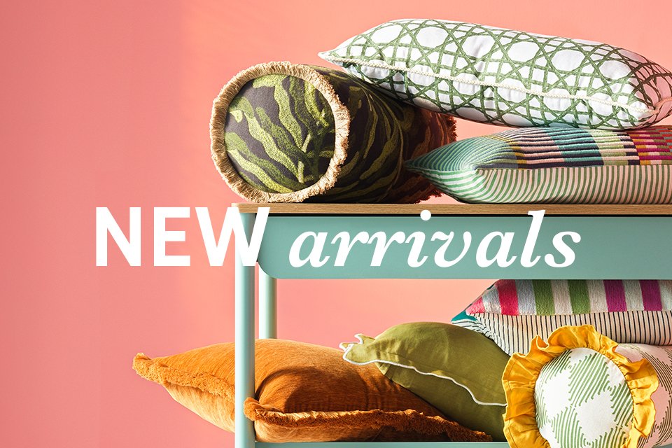 Habitat cushions and pillows in playful prints stacked on a trolley.