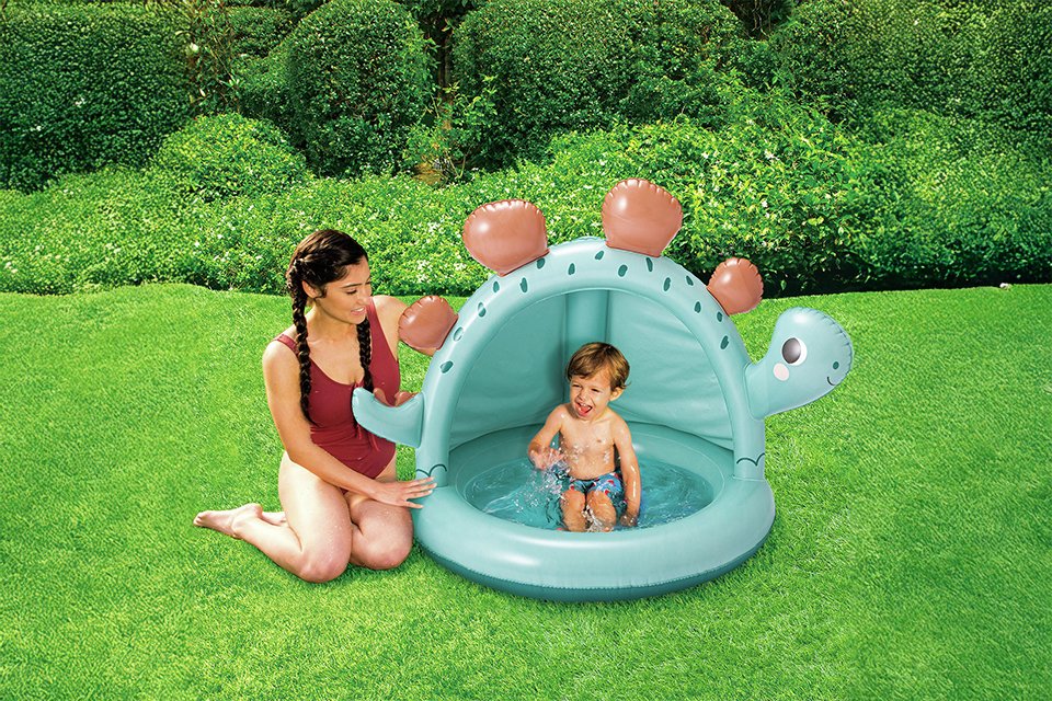 Toddler in a blue Chad Valley pool with his mum sitting next to it in an outdoor setup.
