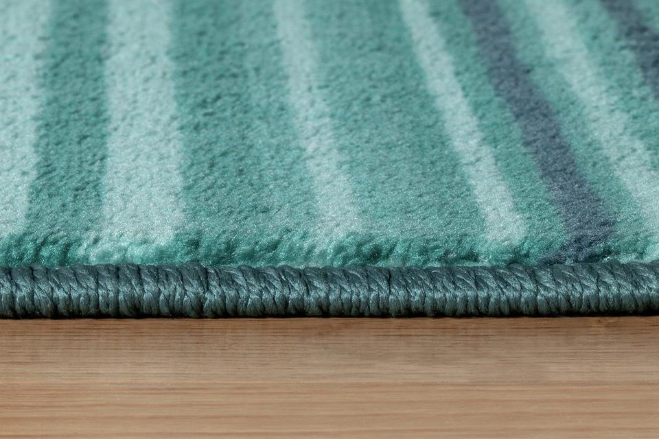 A close up corner shot of a  patterned flatweave rug.