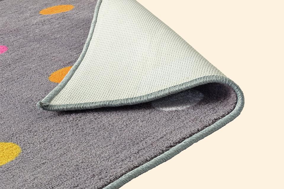 A close up corner shot of a synthetic rug. 