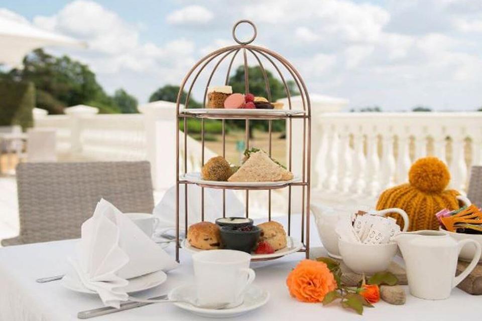 Afternoon tea served on a table on patio outside.