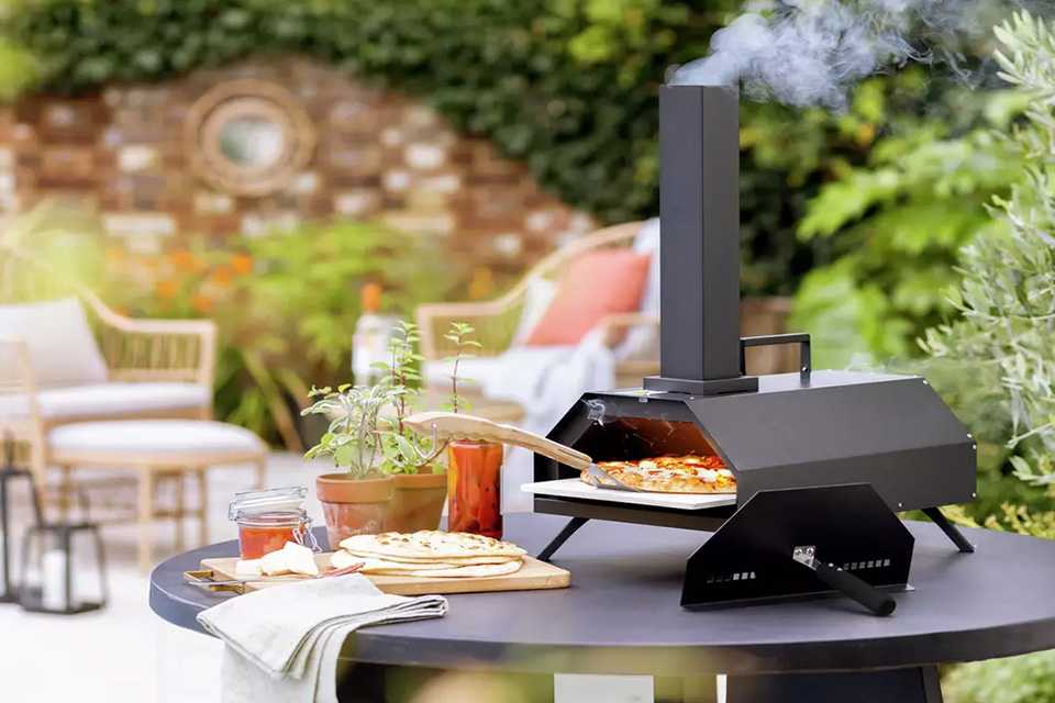 A pizza being cooked in an Argos Home table top pizza oven.